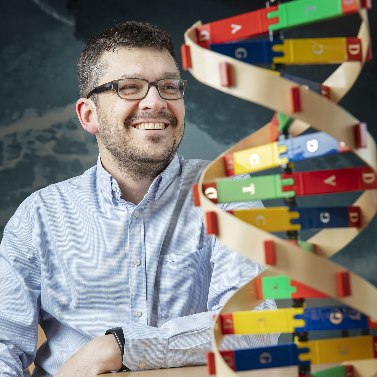 Lärare som sitter vid en DNA-skulptur