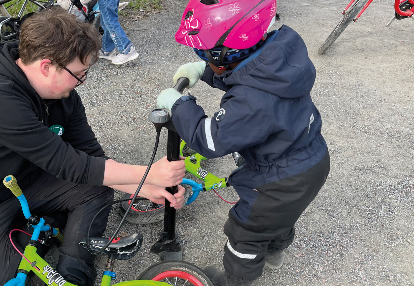 man som hjälper barn med sin cykel