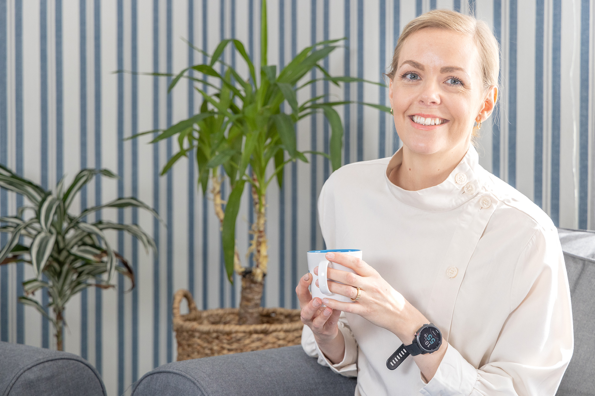 Ellen Jingskog sitter i en soffa och håller en kaffekopp