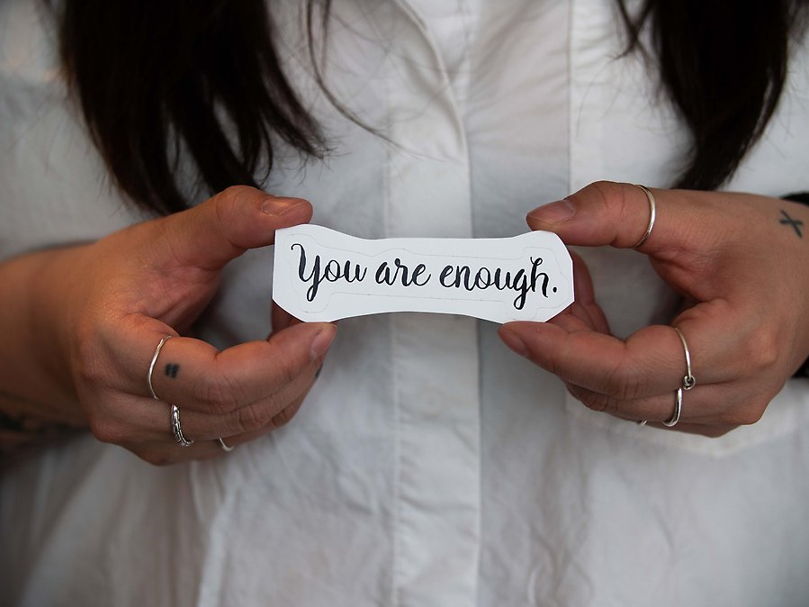 Christina håller i en lapp med texten "you are enough".