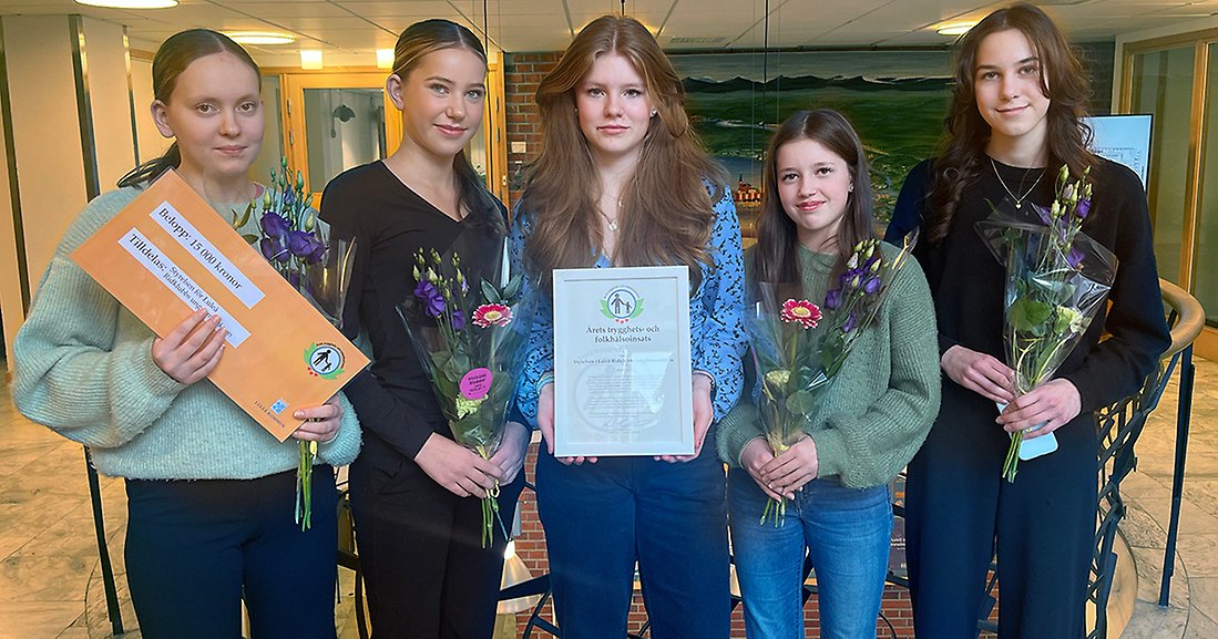Fem tjejer står med blommor och diplom.