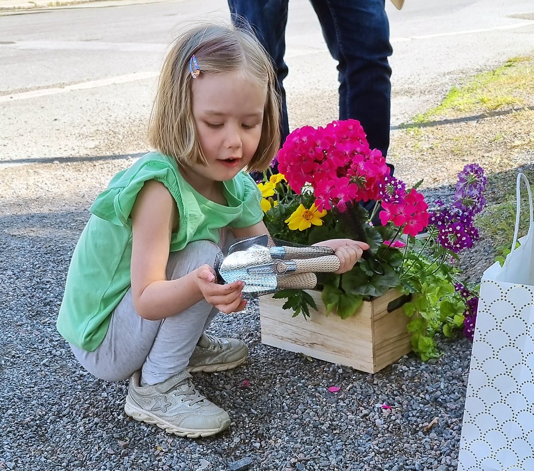 Stella tar emot sitt pris. Ett planteringskit, en blomlåda och en bok som heter ”växter älskar bajs”.
