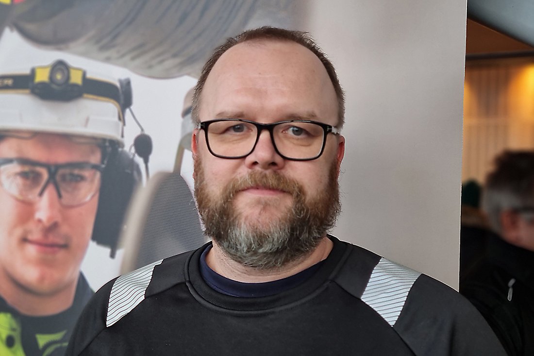 Man med kort mörkt hår och skägg samt glasögon.