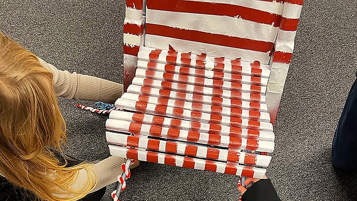 Elever på Öhemsskolan arbetar tillsammans med att linda in sparken i rödvita band.