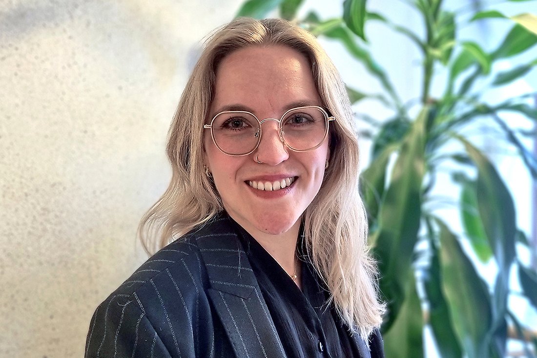 Blond ung kvinna med glasögon som ler