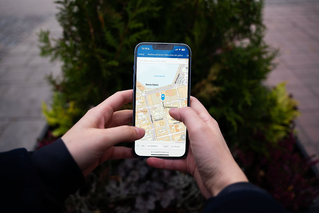 En person håller i en mobil. På skärmen syns en karta över en del av Luleå.