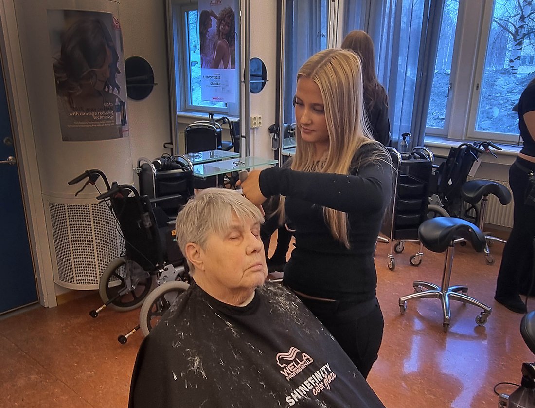 Irma Henriksson njuter i frisörstolen och Flora Häggqvist klipper.