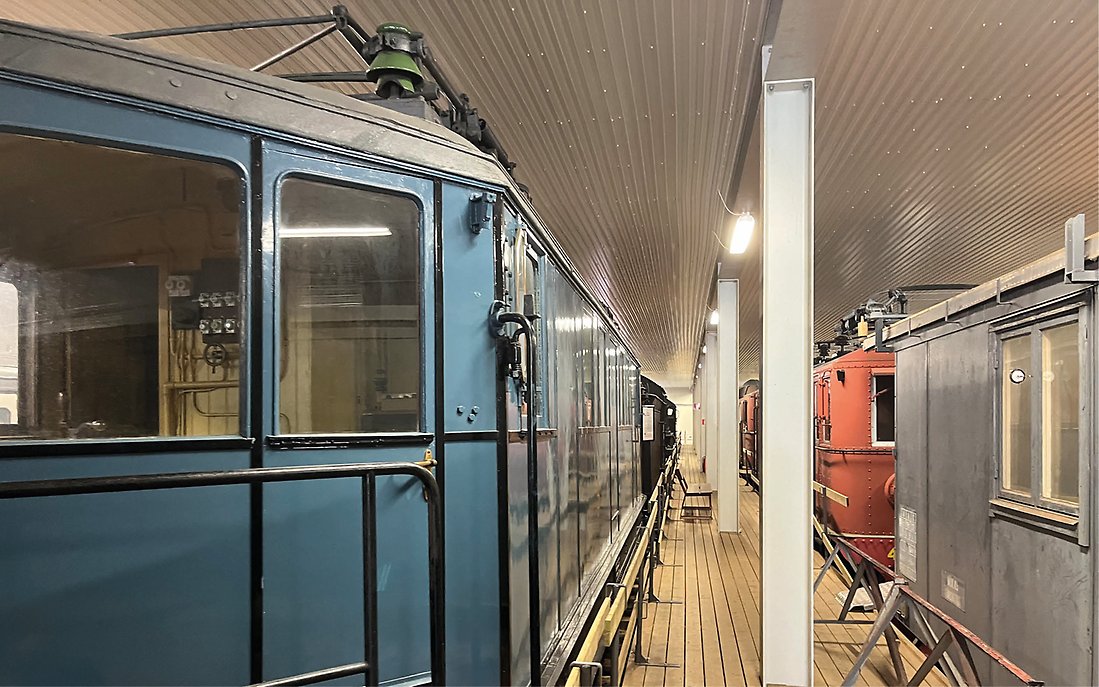 Bild inifrån en av järnvägsmuseets hallar med vagnar och lok.